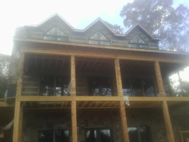 Dormers and porch framing on a large log home under construction — Roof Coating work by our crew in Irmo