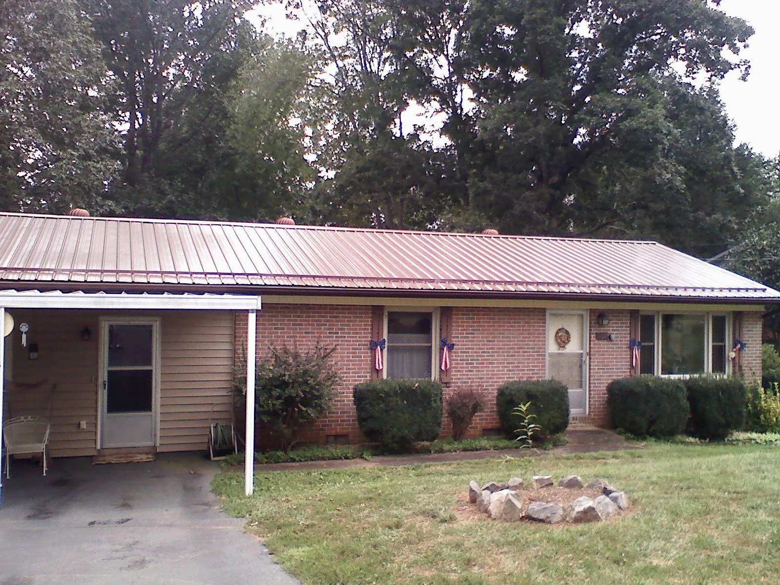 Bronze metal roof and carport on a brick ranch home — Roof Repair work by our crew in Irmo